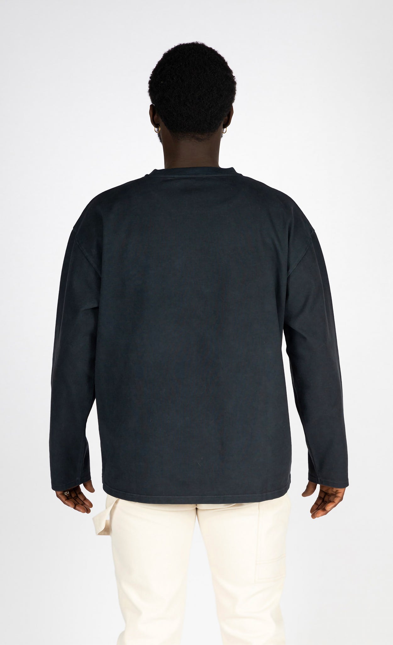 Person wearing a dark long-sleeve polo shirt on a white background