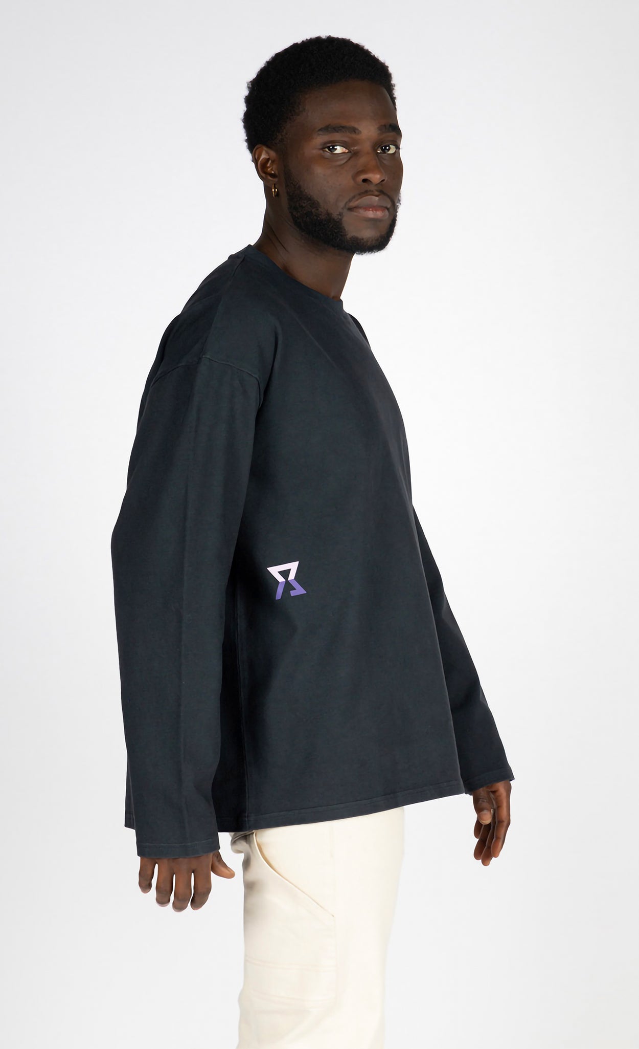 Man wearing a black long-sleeve shirt with a logo on a white background