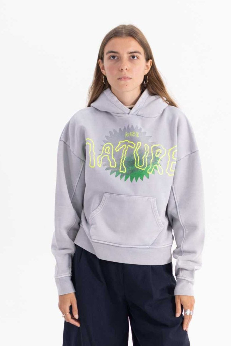 Person wearing a grey hoodie with green text on a white background made with 50% recycled cotton