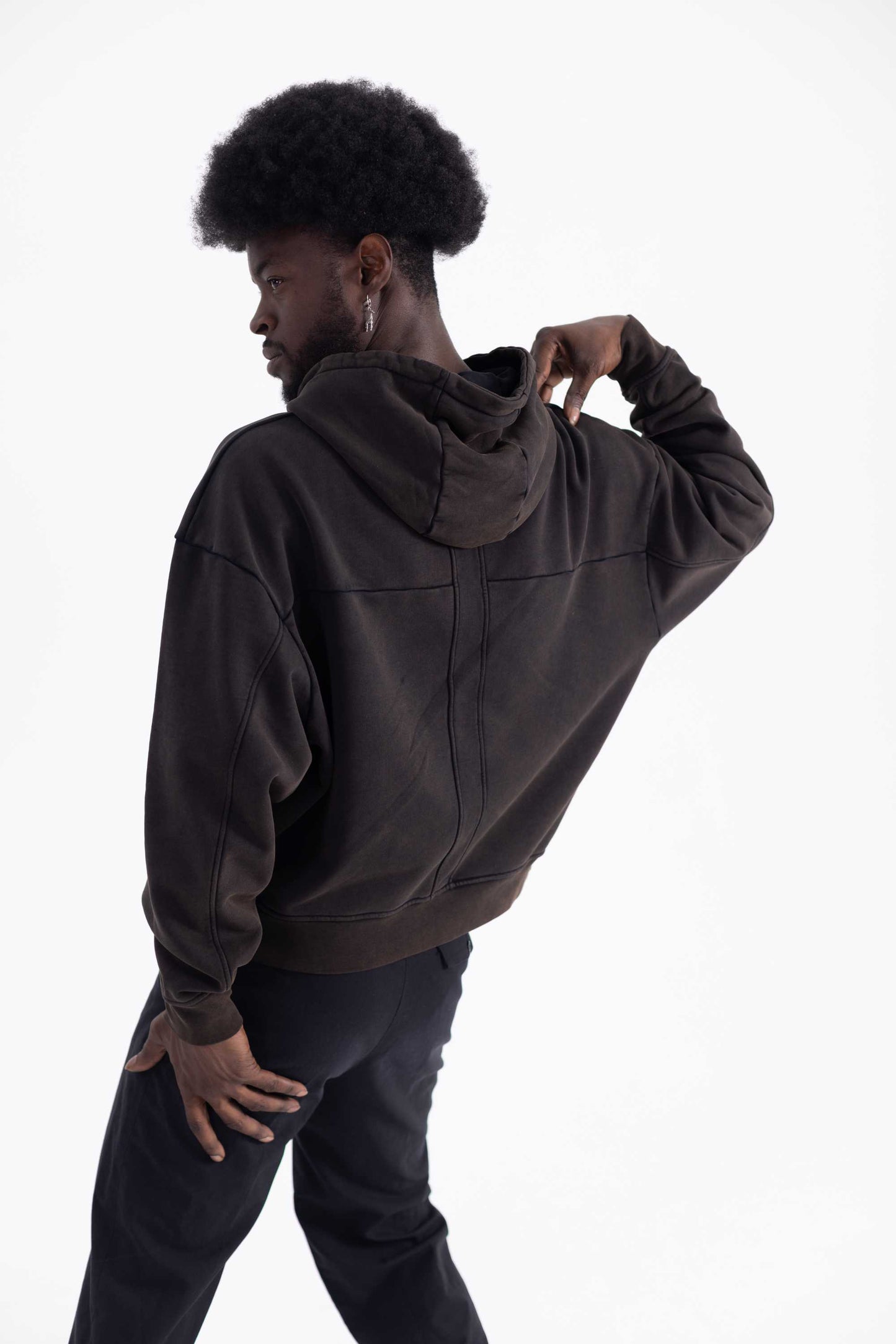 Person wearing a dark brown hoodie on a white background