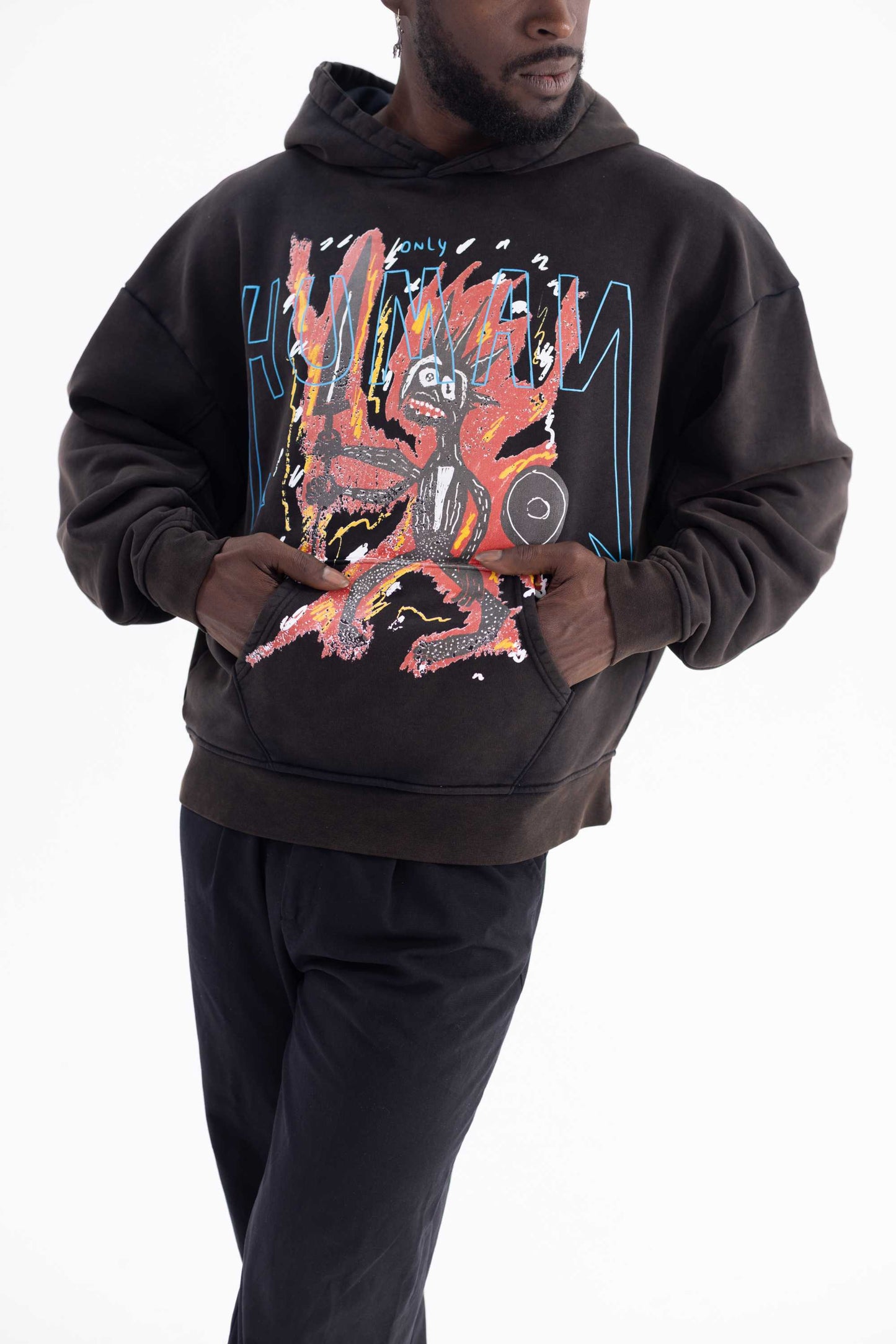 Person wearing a black hoodie with a colorful graphic design on a white background made with sustainable materials