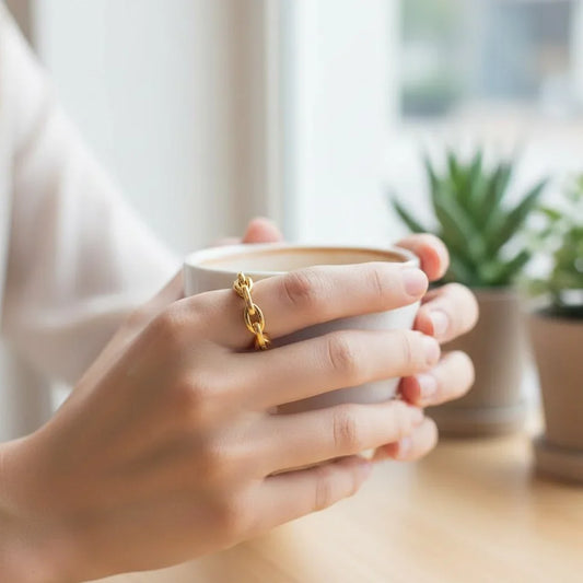 Gold Ring worn on the first finger and the woman is holding a cup of cofee