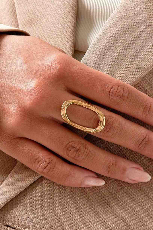 Gold ring on a person's finger with a neutral background