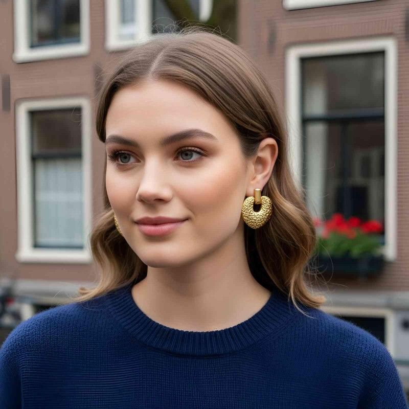 Woman wearing gold hoop earrings in an urban setting