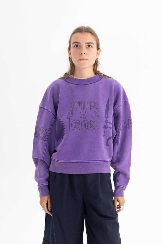 Person wearing a purple sweatshirt with text on a white background