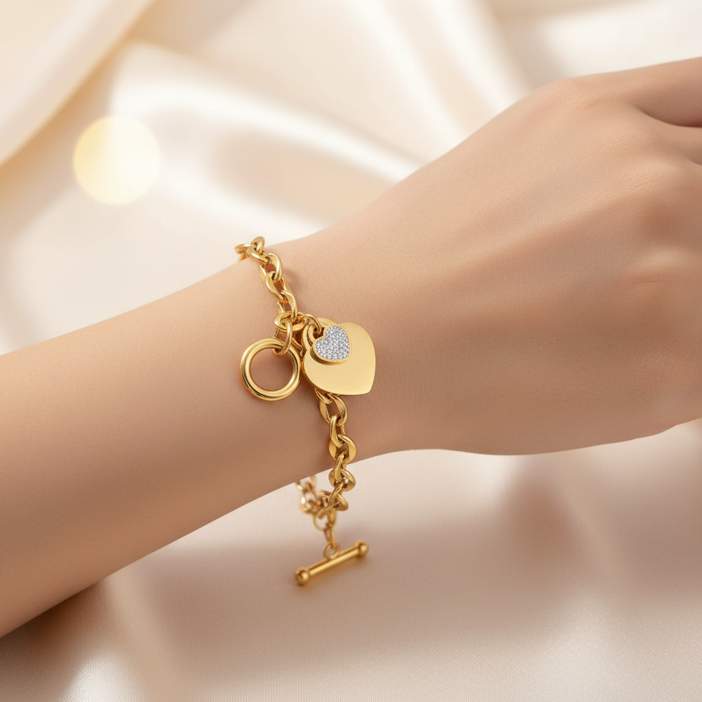 Gold bracelet with heart-shaped charm on a wrist against a soft background | Gbaje Jewelry