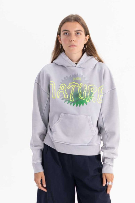 Person wearing a grey hoodie with green text on a white background made with 50% recycled cotton