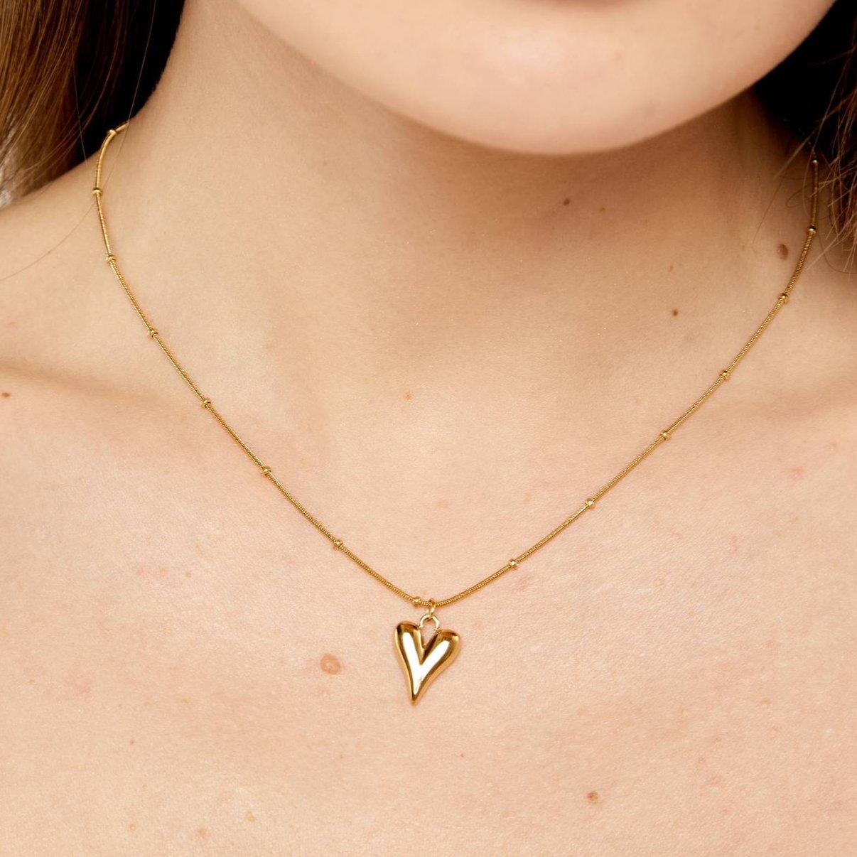 Gold heart necklace on a woman's neck