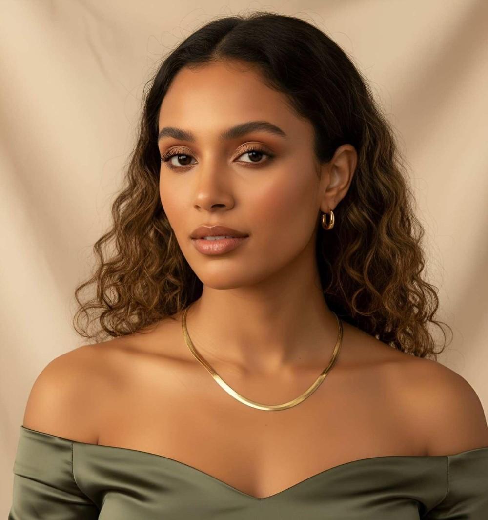 A gold snake chain worn by a female model